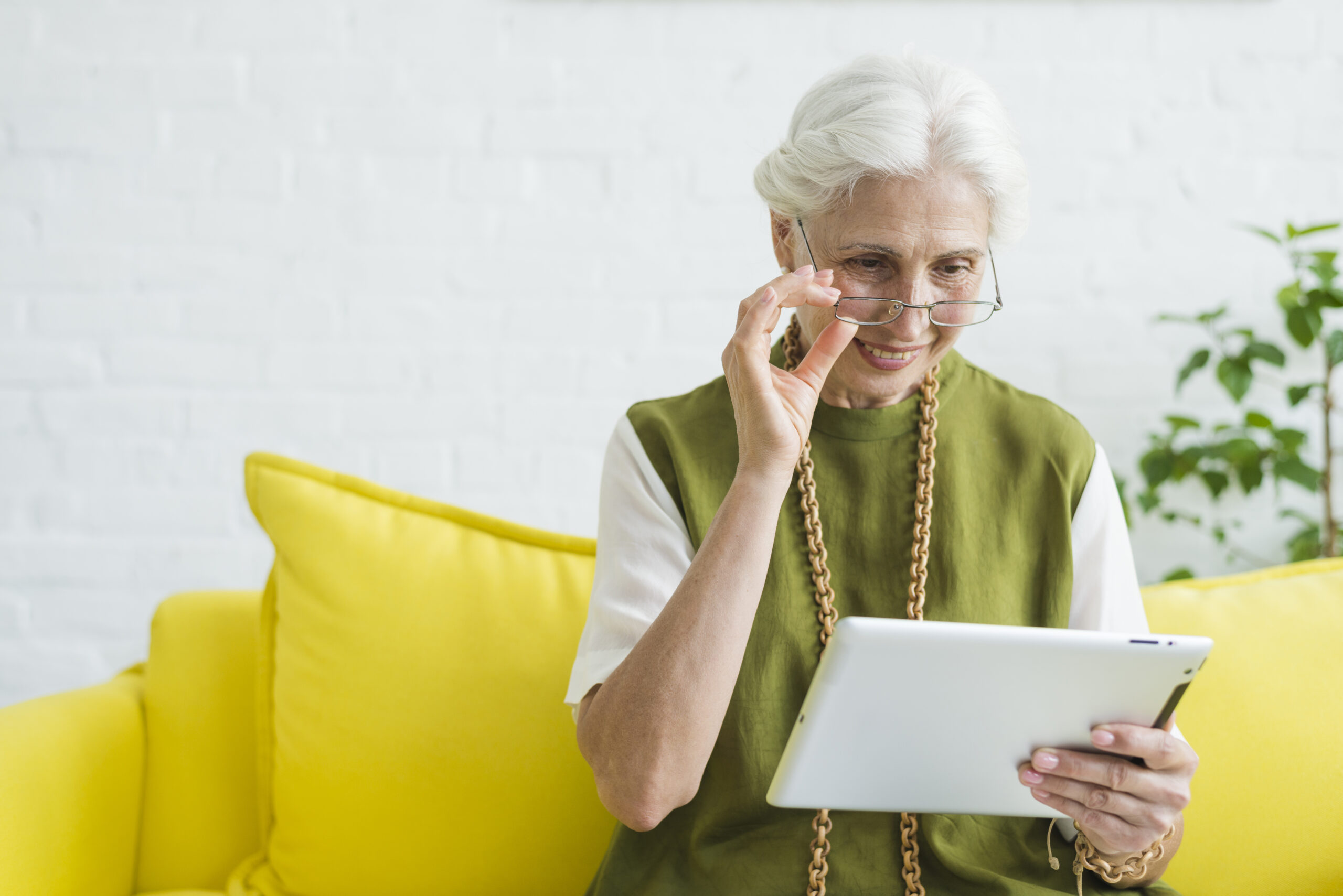 Elderly woman smiling while using IbisHub for a remote health session.