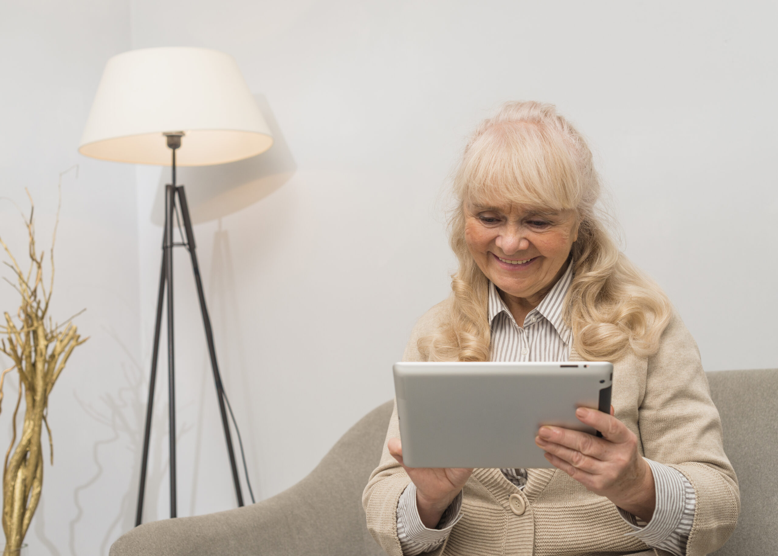 Senior woman using IbisHub tablet for her virtual care session at home.