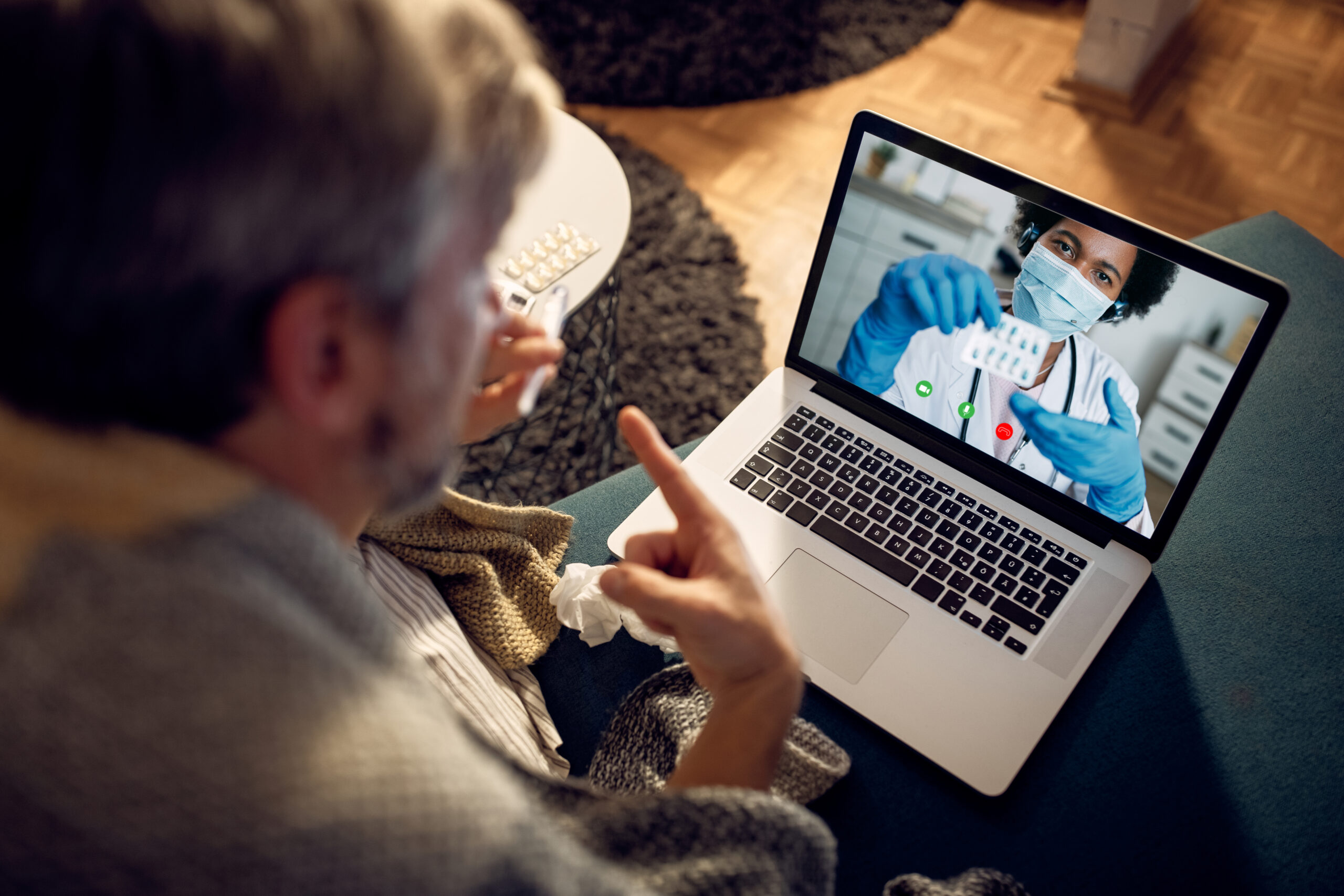Elderly man checking vitals with Ibis-connected device from home.