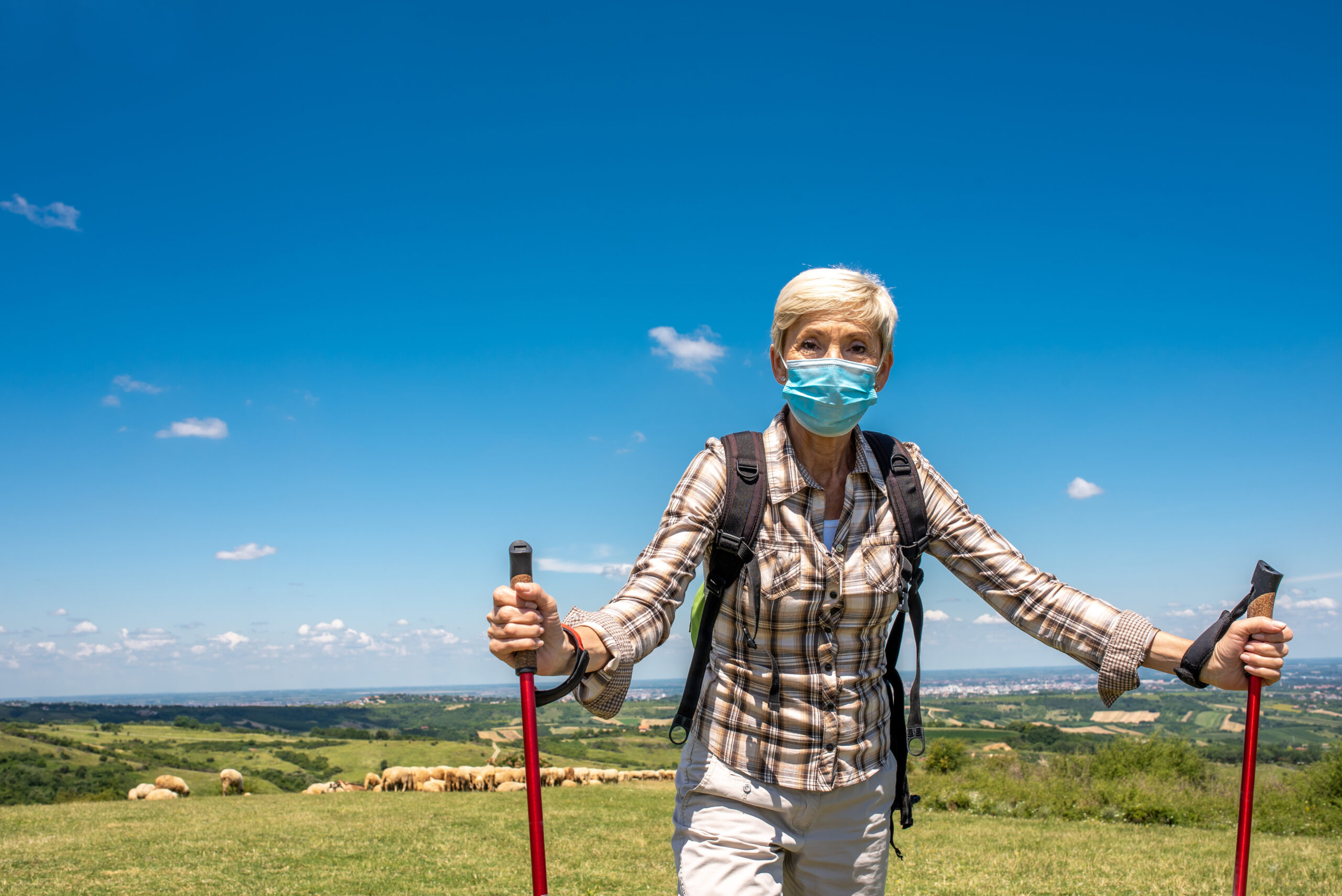 Active senior woman hiking safely outdoors with Ibis support for her chronic care.